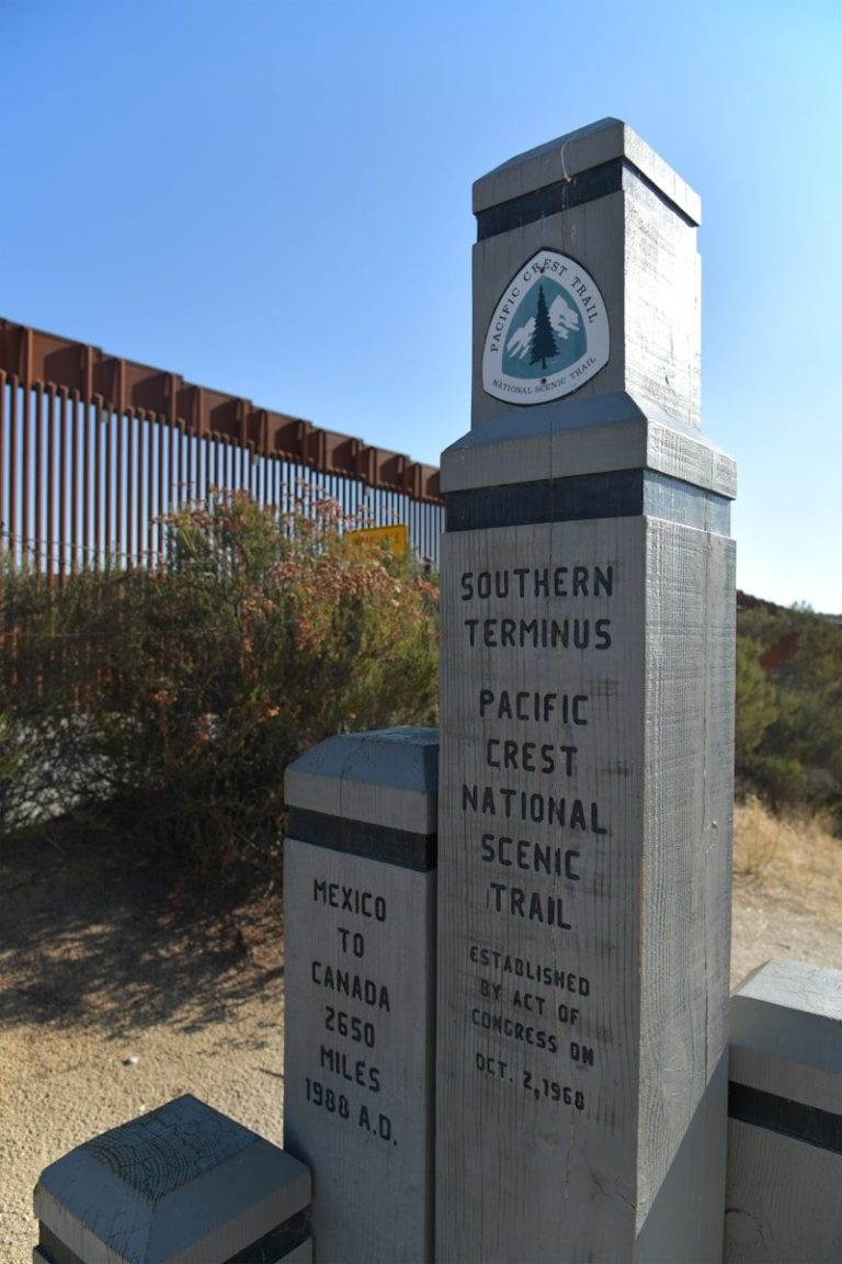 A monument in front of a border fence
